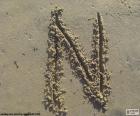 Буква «N» в заглавной буквы, написанные на песке на пляже